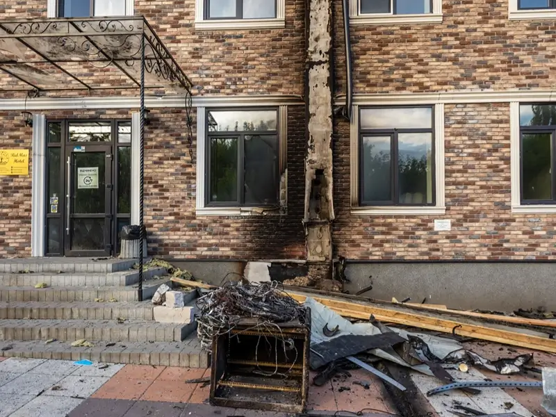 Fire-damaged brick building with debris outside.