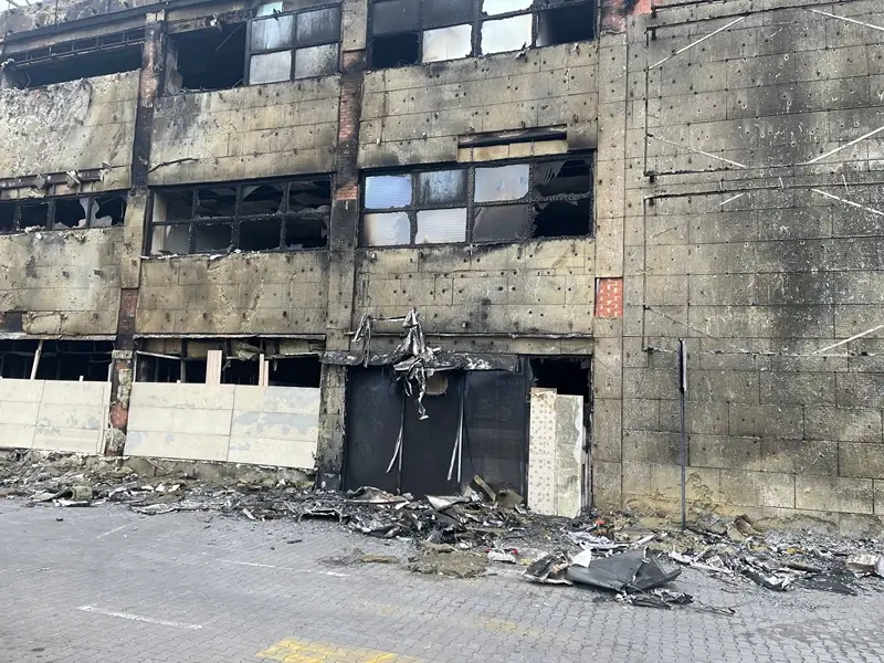 Burned-out building facade with shattered windows and debris.